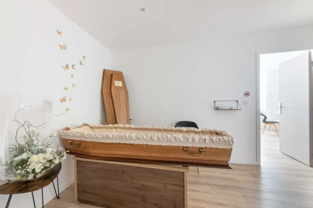 Chambre funéraire aménagée avec un cercueil en bois pour le recueillement des proches.